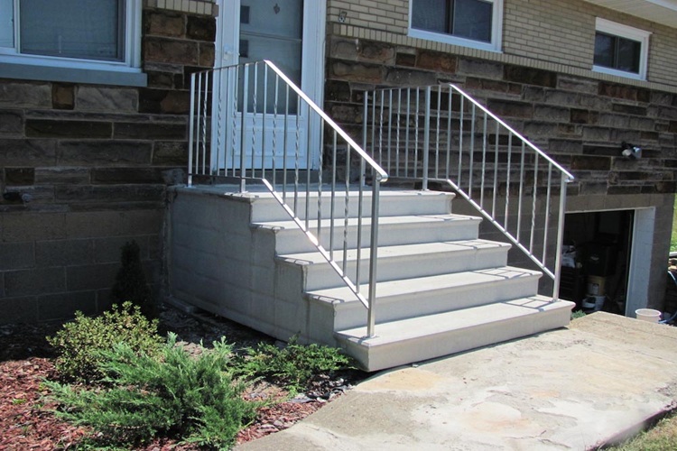 Precast concrete steps with a matching aluminum railing on each side