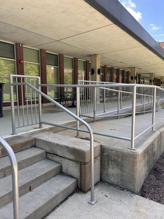 Aluminum pipe railings with a wheelchair wheel guard at Carlow University